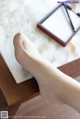 A woman's foot sitting on a table next to a mirror.