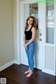 A woman standing in front of a white door.