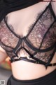 A close up of a woman wearing a black bra.