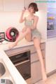 A woman sitting on top of a kitchen counter next to a sink.