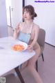 A woman sitting at a table with a plate of food.