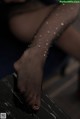 A close up of a woman's legs in fishnet stockings.