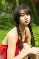 A woman in a red dress sitting on the ground.