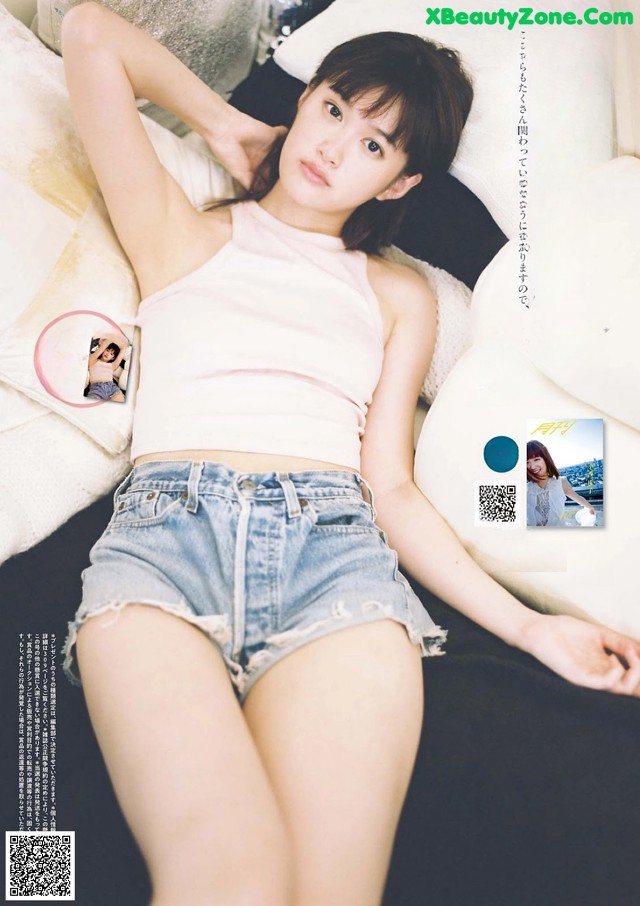 A woman laying on top of a bed next to pillows.